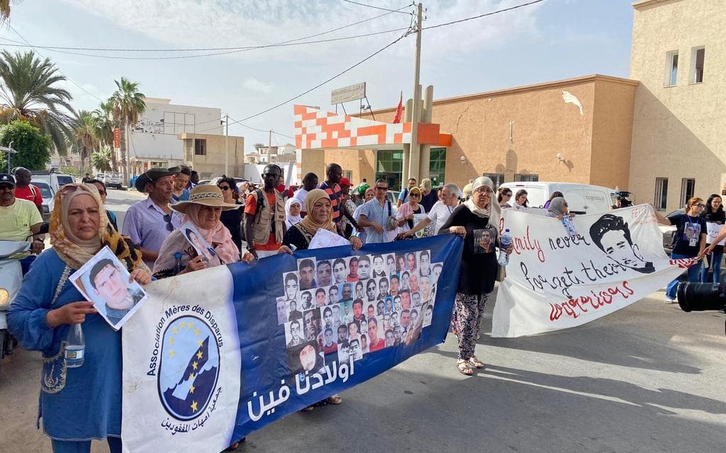 The pictures shows the first row of a demonstration. Approx. 8 people are holding banners denouncing the death and forceful disappearance of migrants on their way to the EU.